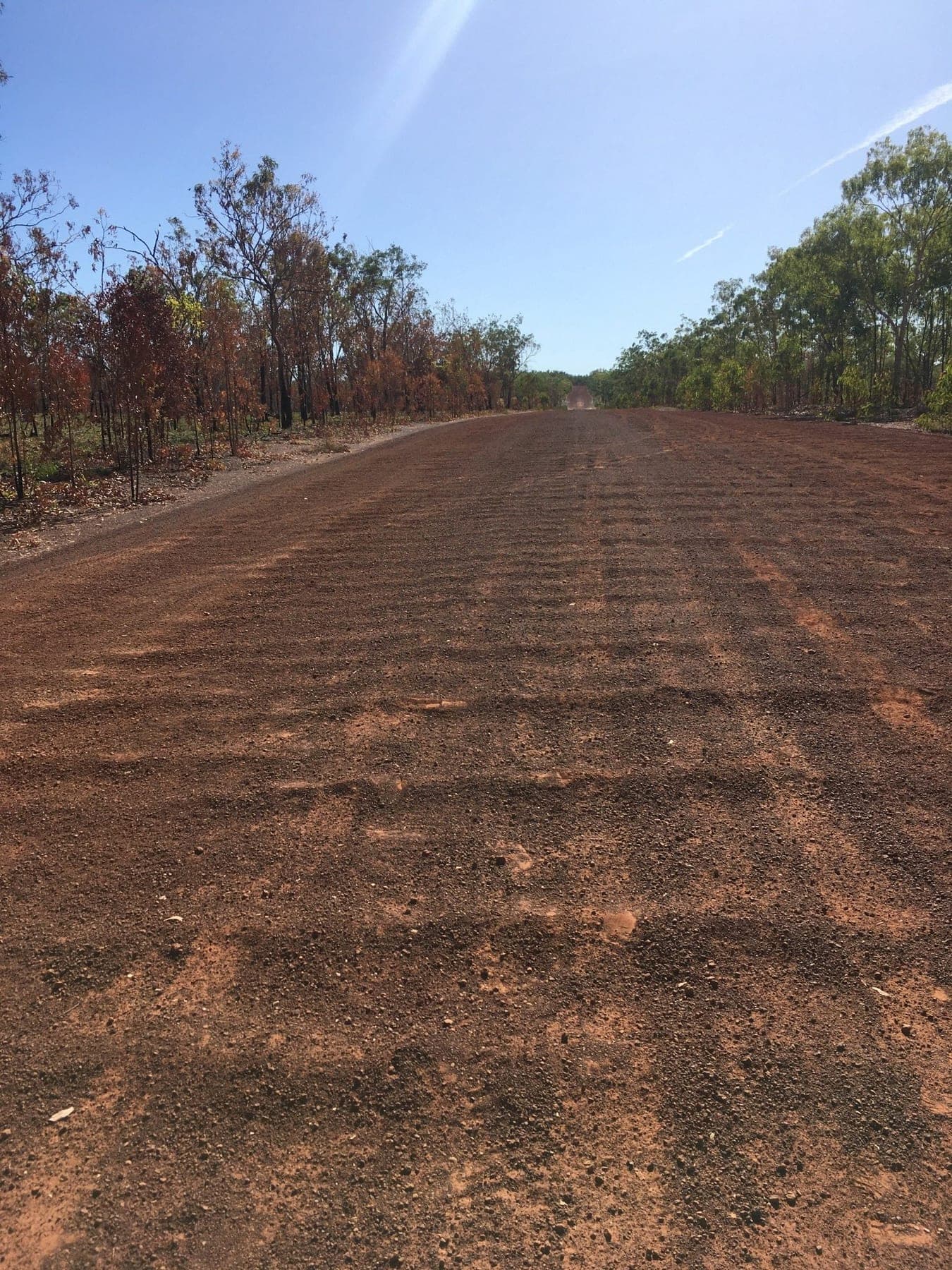 The tour coach on a red corrugated outback road