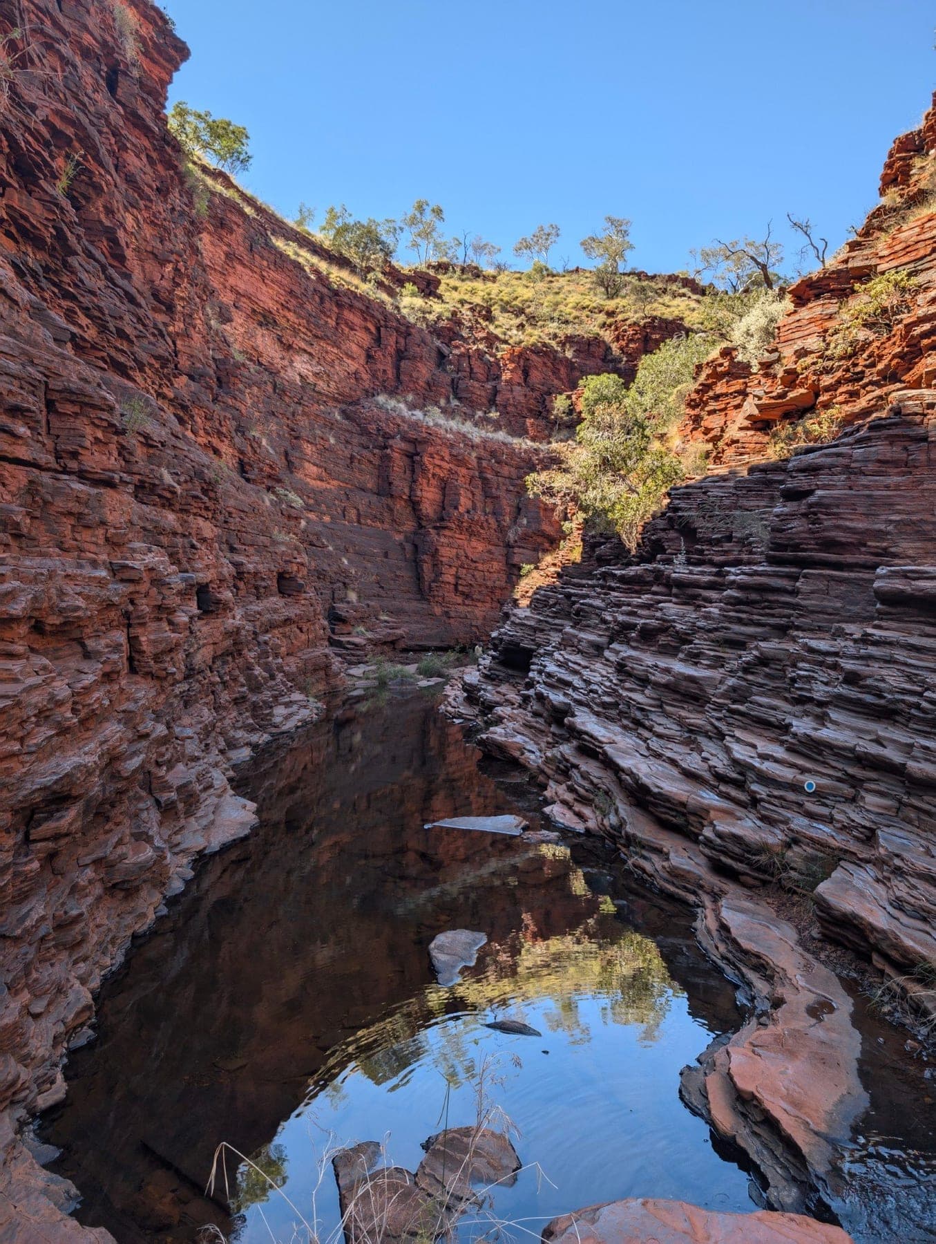 Deep red gorge walls and a green pool in Karijini National Park
