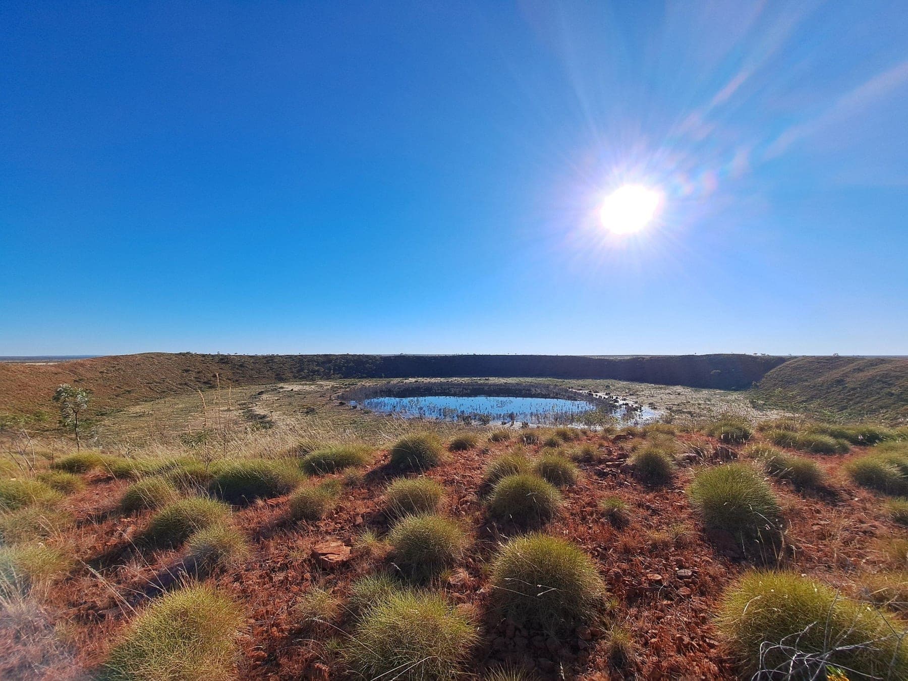 Wolfe Creek Crater seen from the rim with spinifex in the foreground
